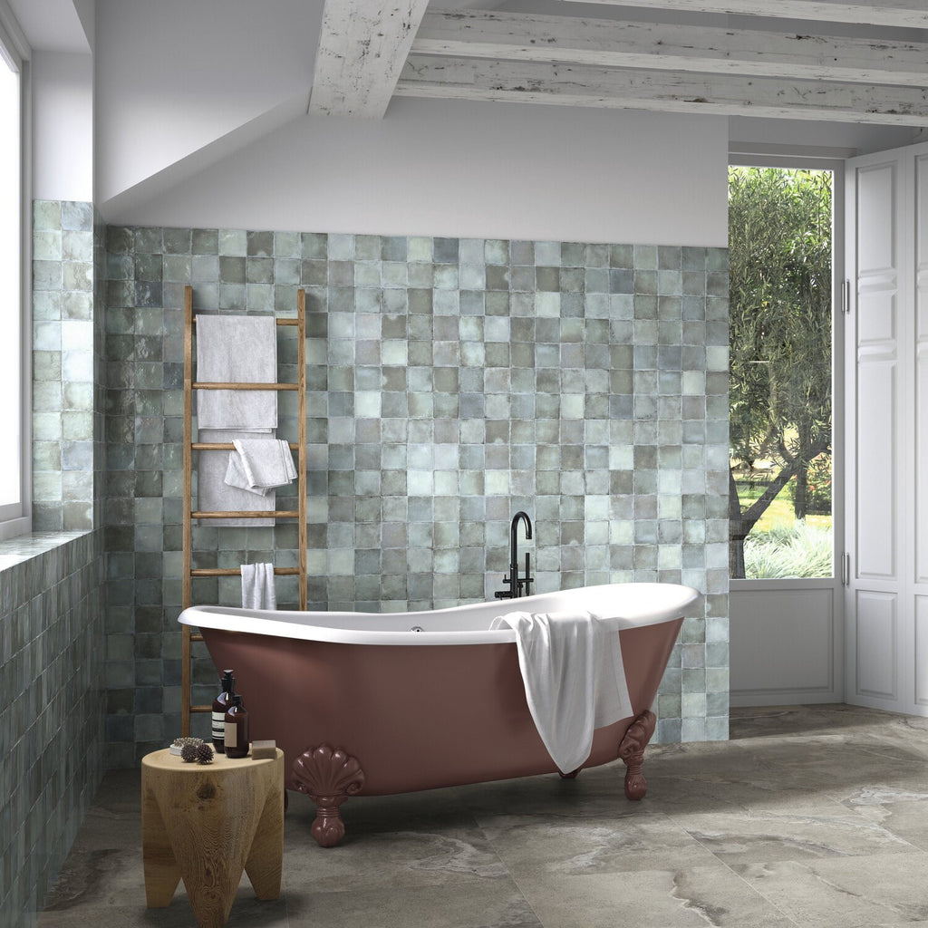 Rustic bathroom featuring a bronze red clawfoot tub and tiled tub surround made out of glossy blue-gray ceramic 4x4 square tiles.