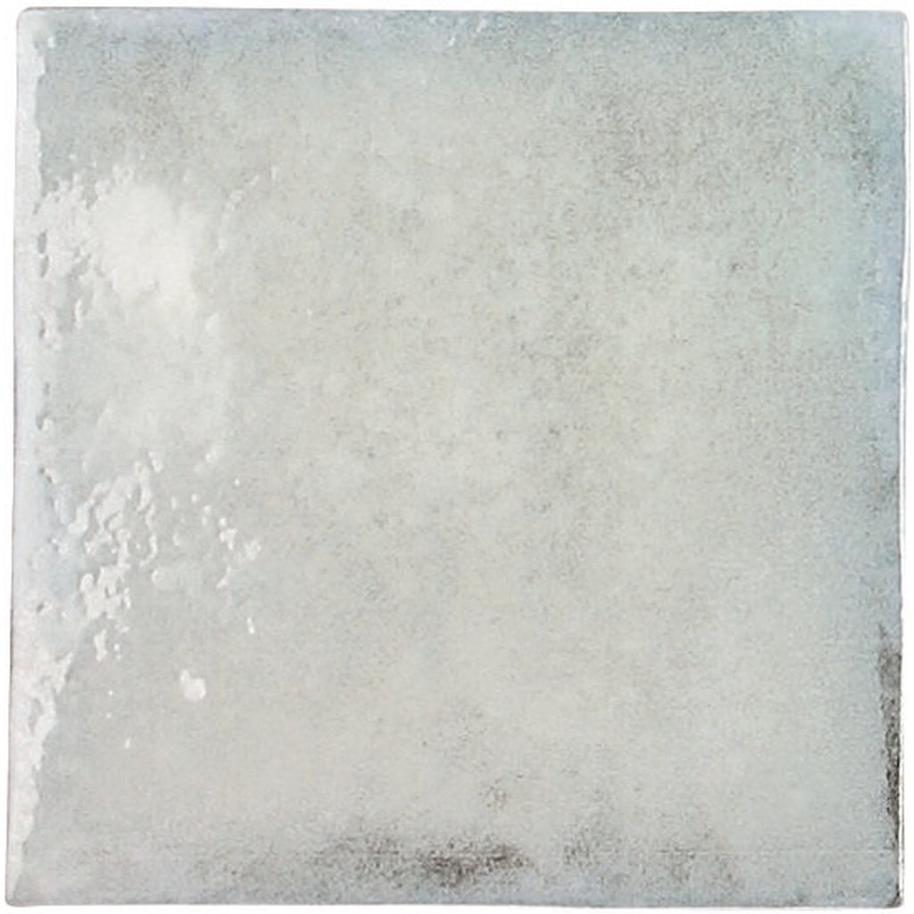 Closeup of a single bluish-gray glossy ceramic 4x4 square tile for walls.